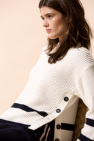 Oui Viniah seated model in ribbed jumper tucked into jeans, showing stripe