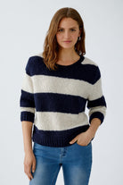 Model wearing striped wool blend jumper in navy and cream