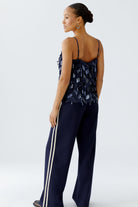 Back view of Oui sequin cami styled with matching navy trousers