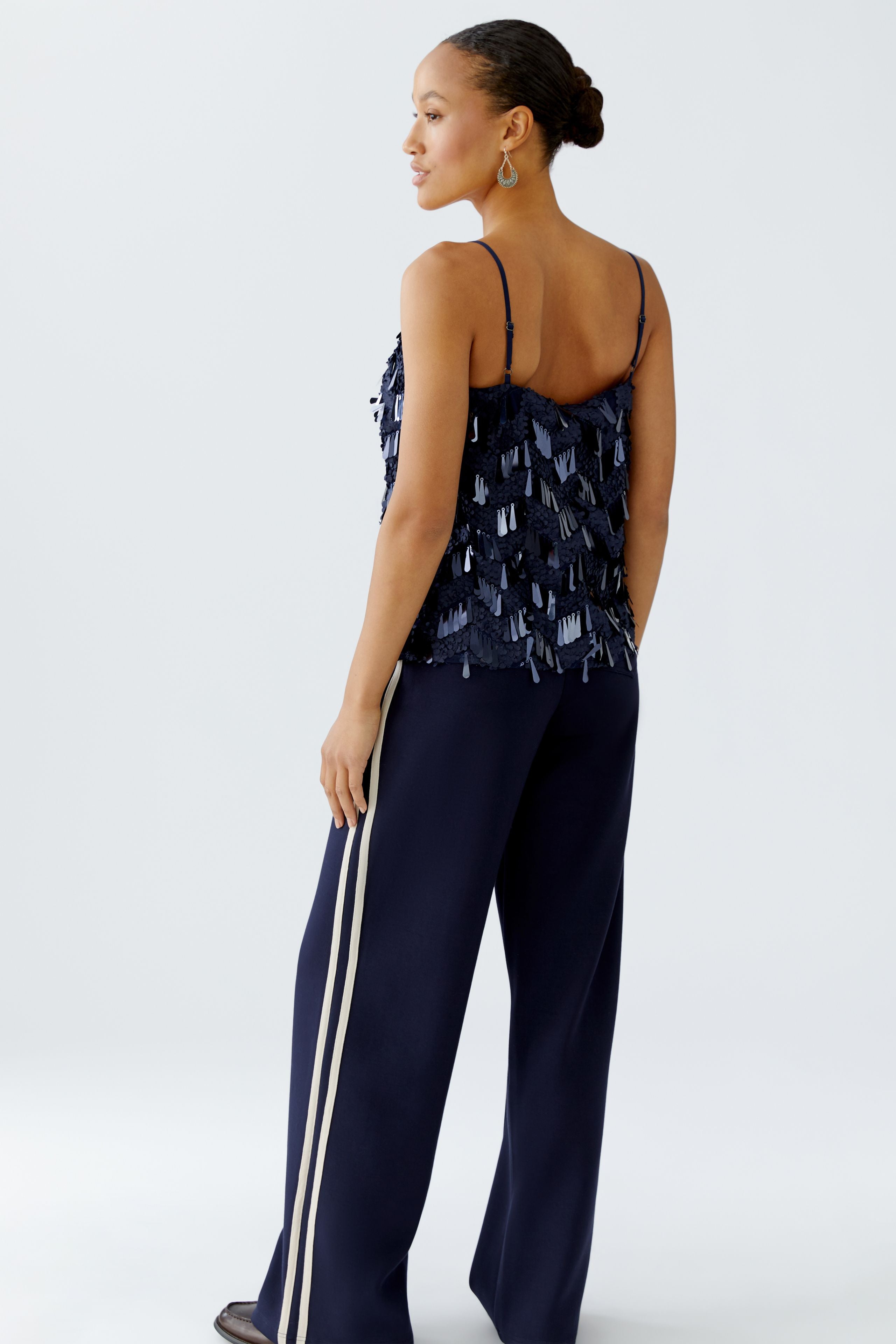 Back view of Oui sequin cami styled with matching navy trousers