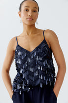 Model in Oui navy cami and wide-leg trousers, relaxed pose