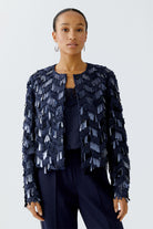 Model wearing dark blue Oui sequin jacket with navy trousers, front view