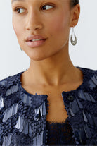 Close-up of model’s face and neckline of the Oui dark blue sequin jacket