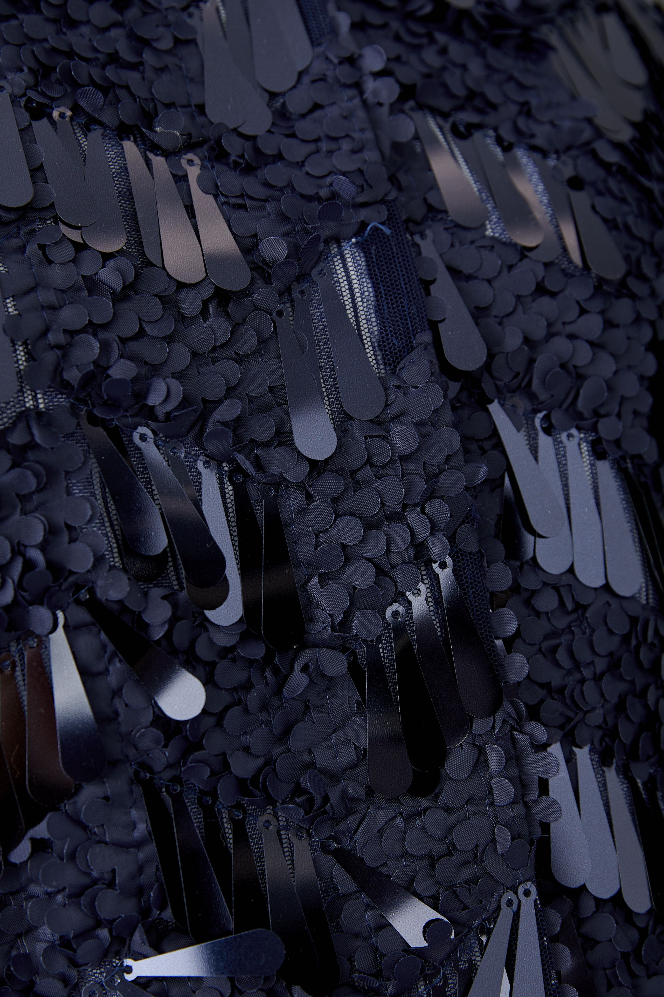 Close-up of glossy navy sequin detailing on Oui jacket