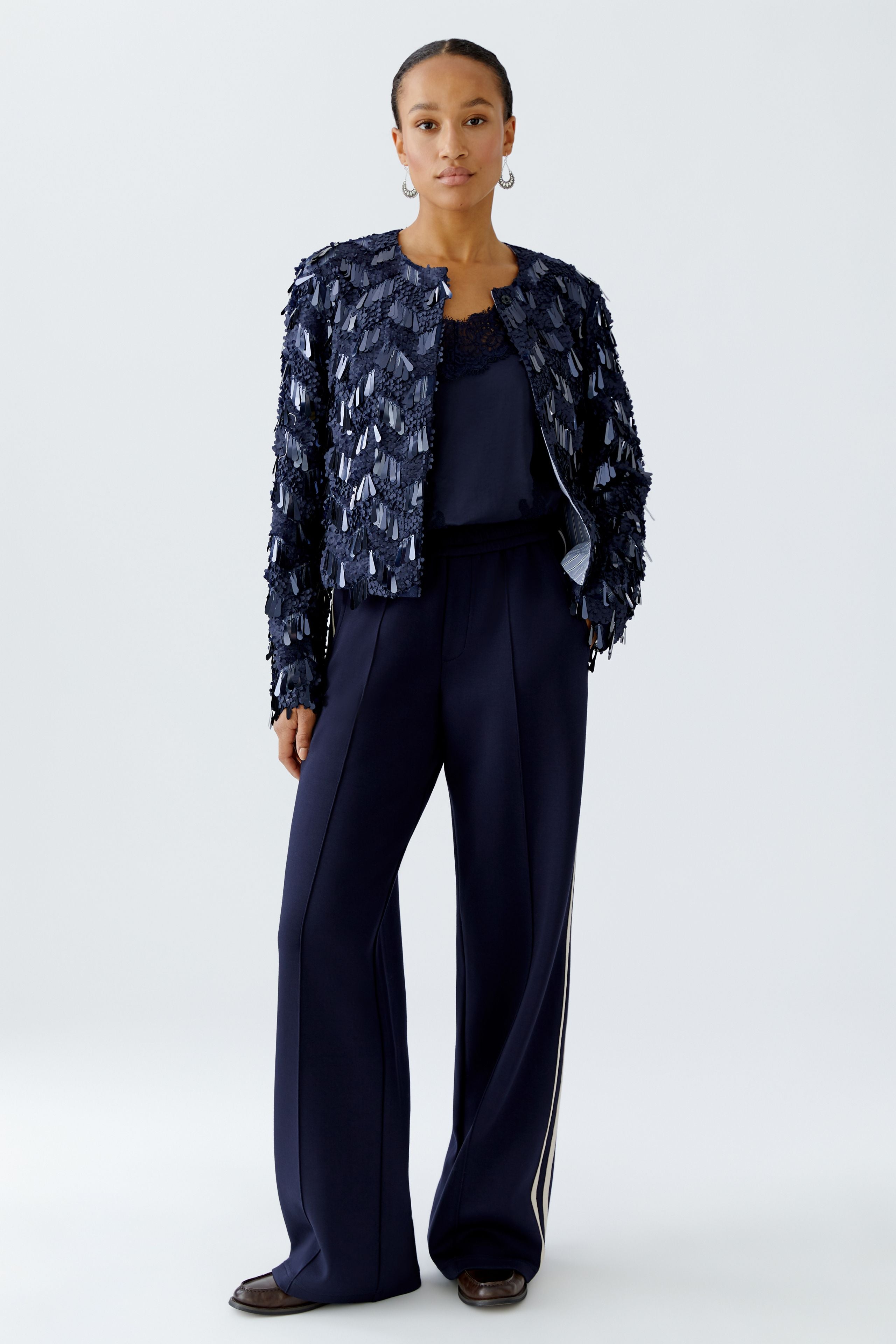 Full-length shot of model in navy sequin jacket and wide-leg trousera