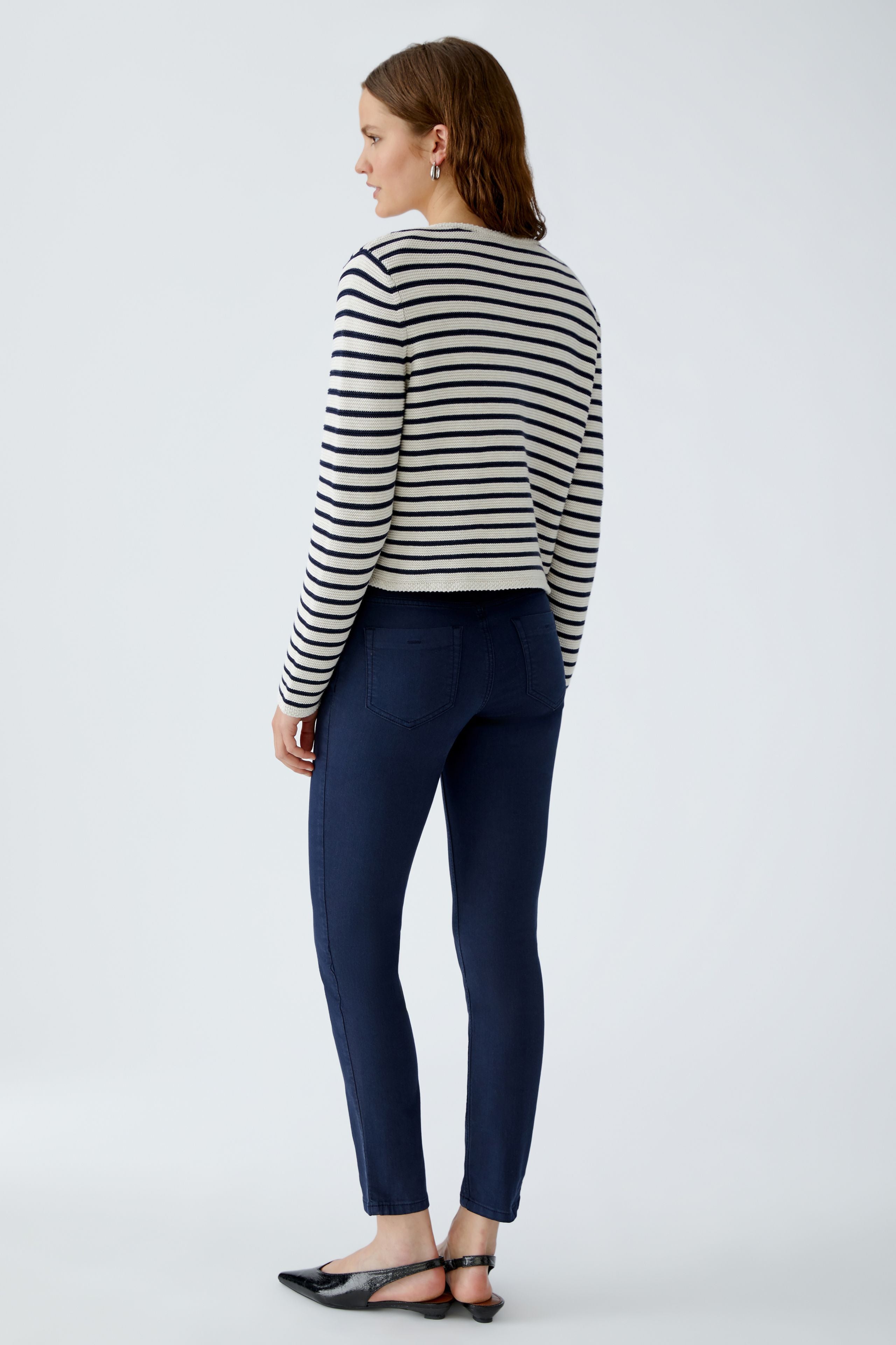 Back view of model in Oui navy/white stripe cardigan and navy trousers