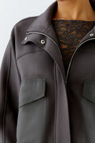 Close-up of front with contrast nylon patch pockets and zip collar
