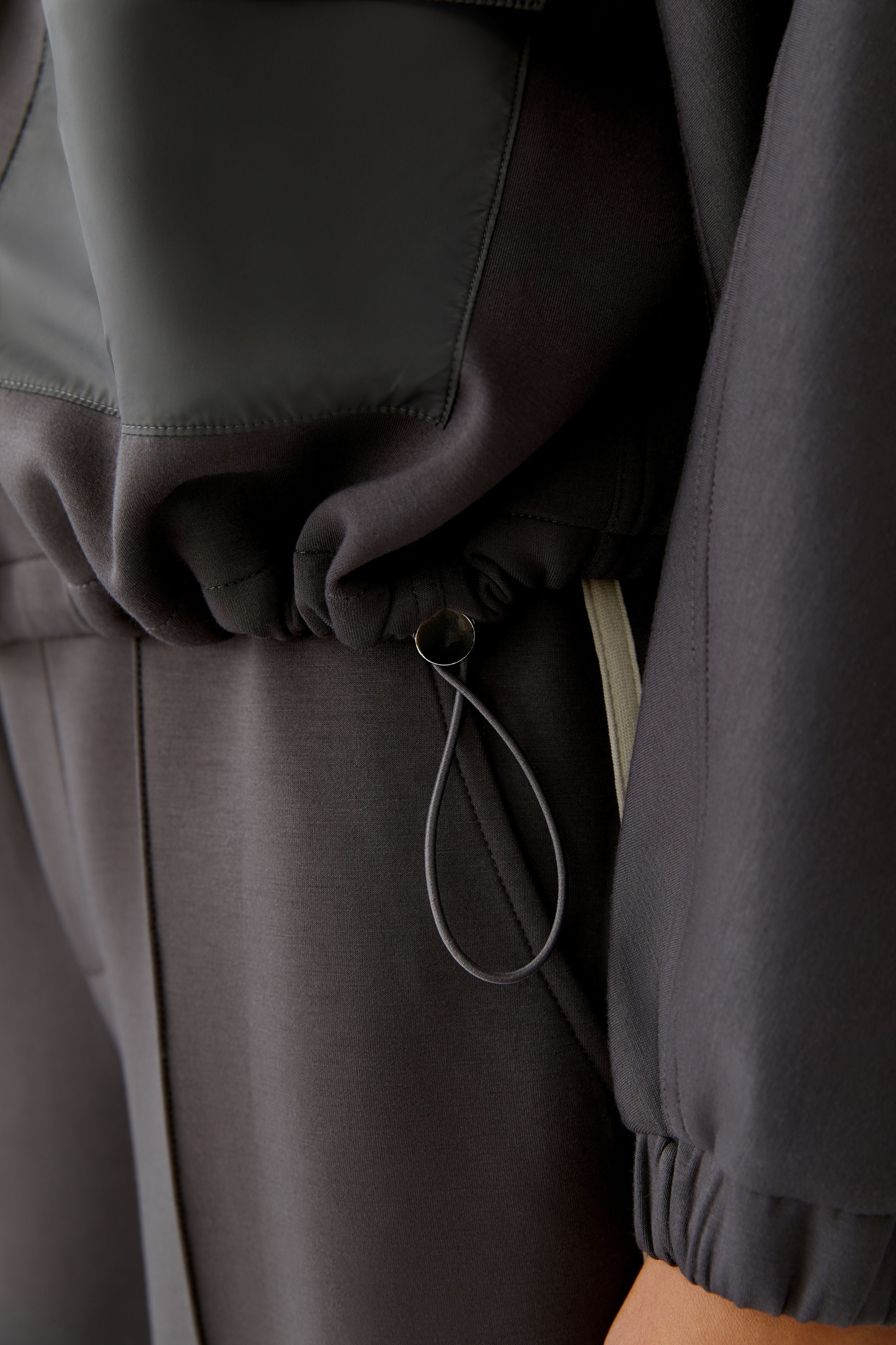 Detail of drawstring hem on Oui dark grey scuba jacket