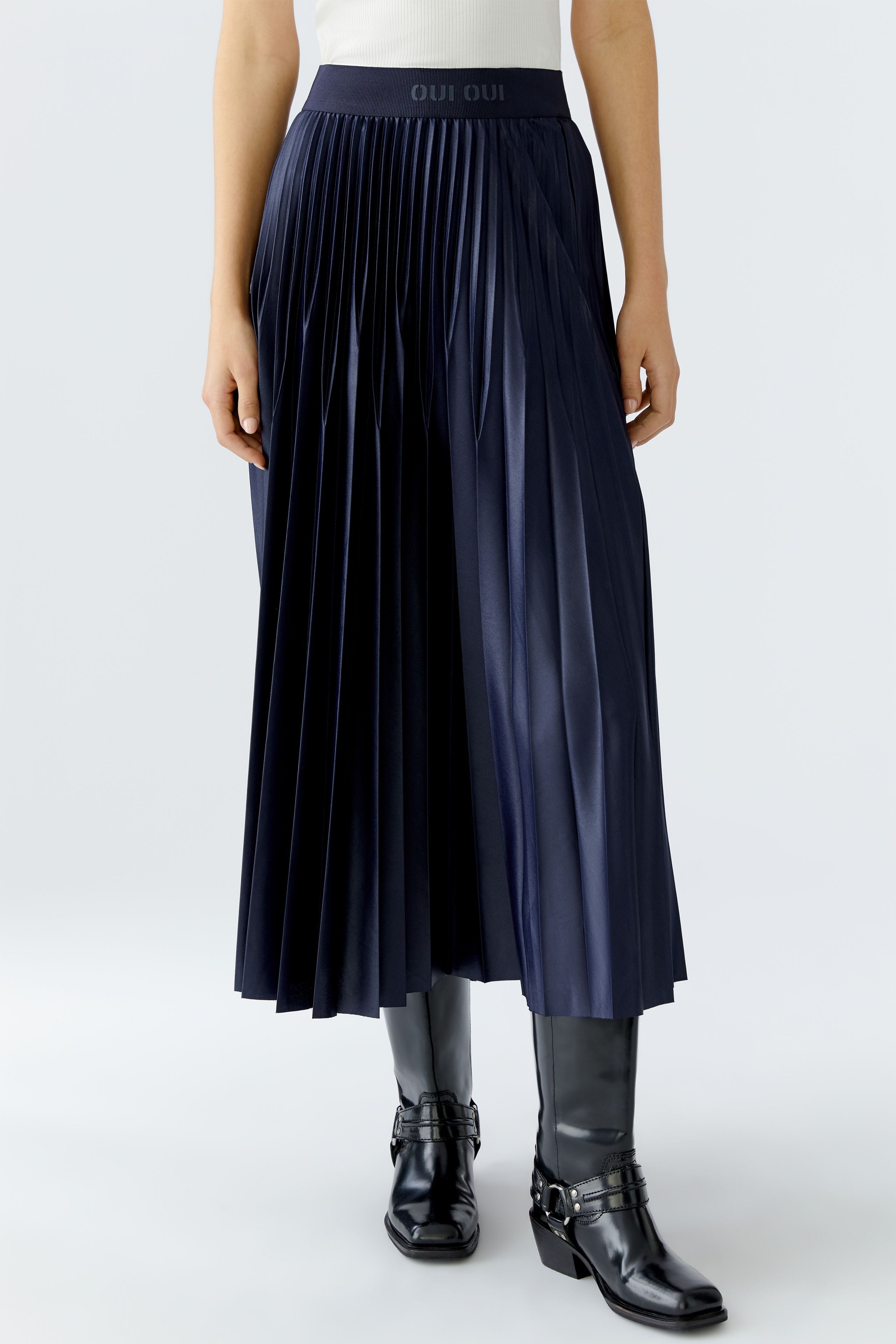Front view of navy pleated midi skirt showing soft pleats and gloss finish