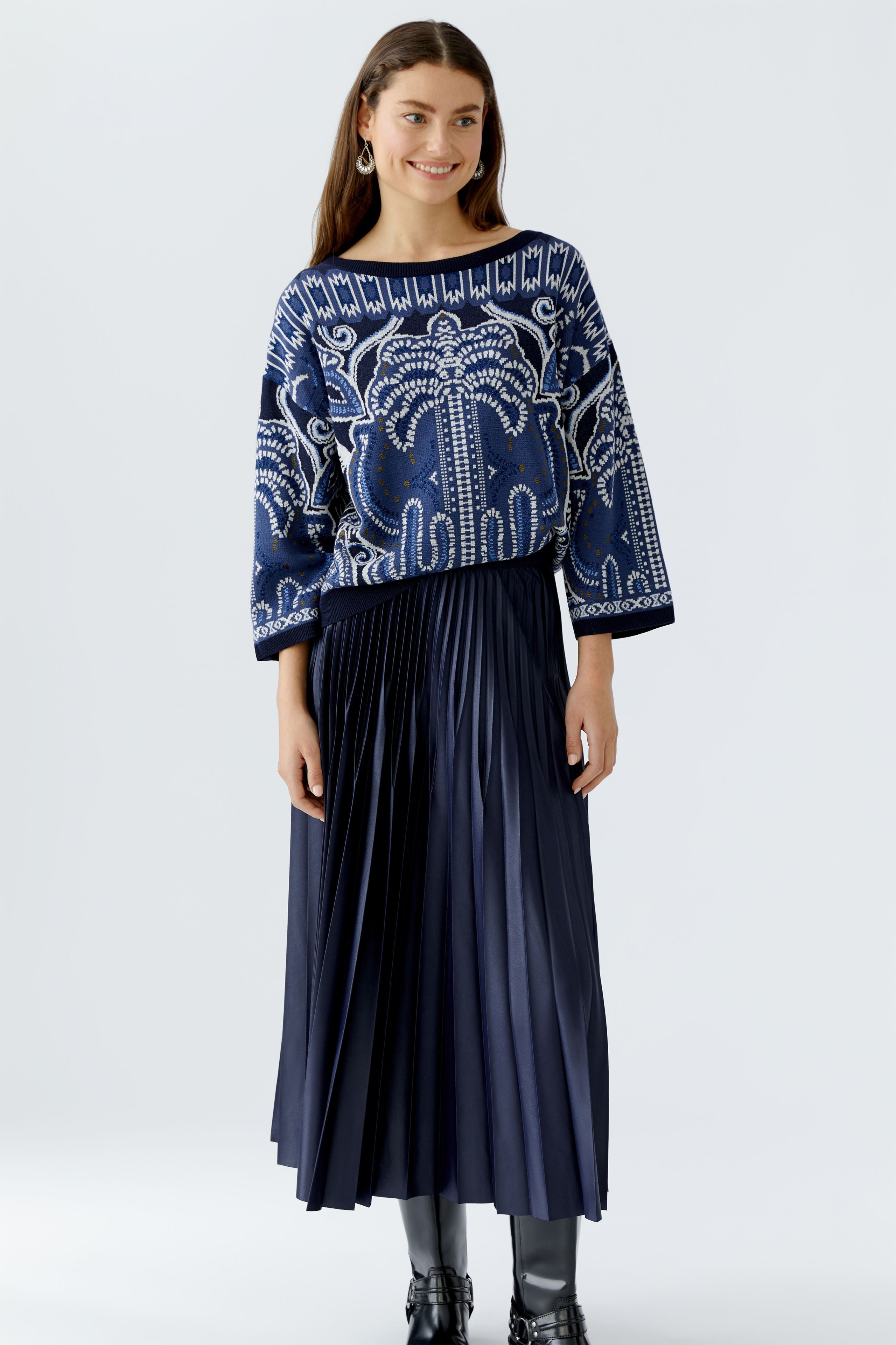 Oui pleated skirt styled with oversized knit and black boots