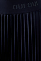 Detail of glossy navy pleated midi skirt and fabric texture