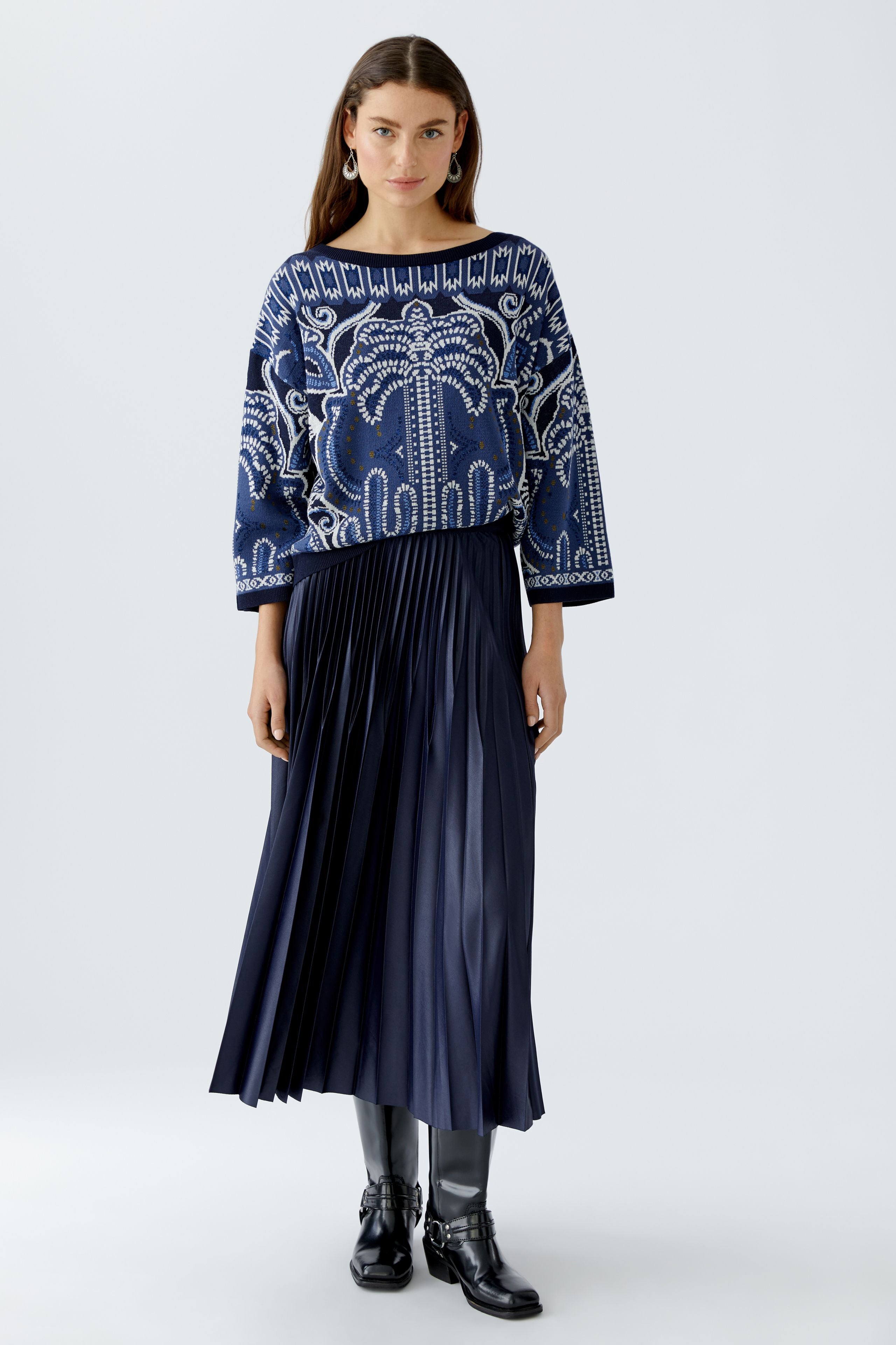 Model in Oui navy silky pleated midi skirt with blue patterned jumper
