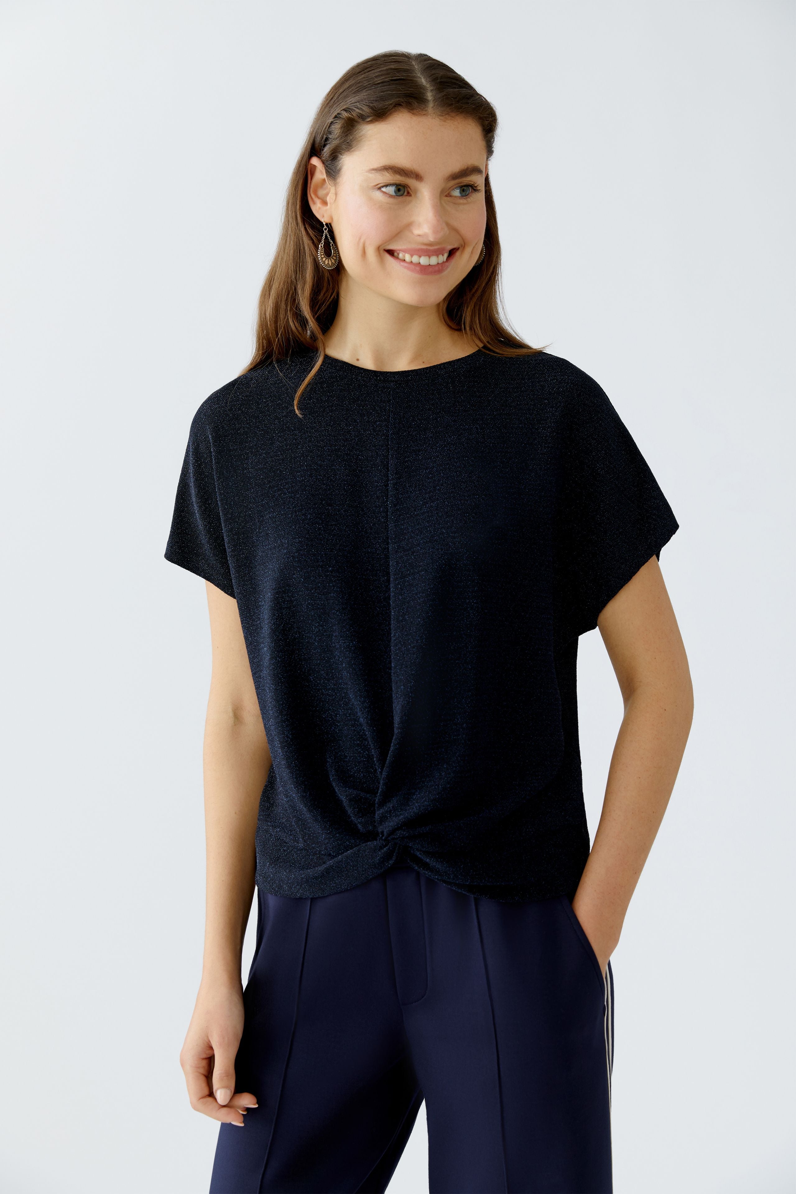 Model wearing dark blue shimmer top and navy trousers