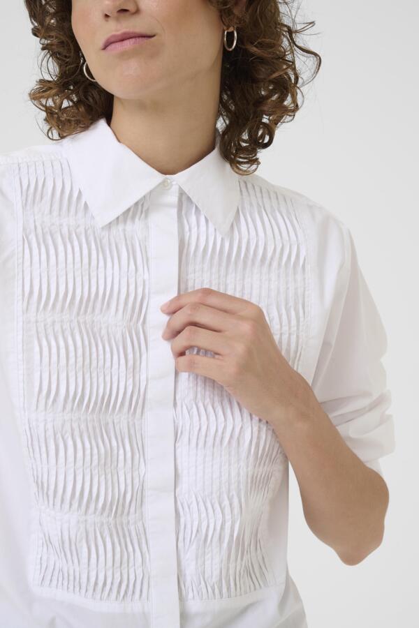 Close-up of smocked front panel on white cotton part two shirt