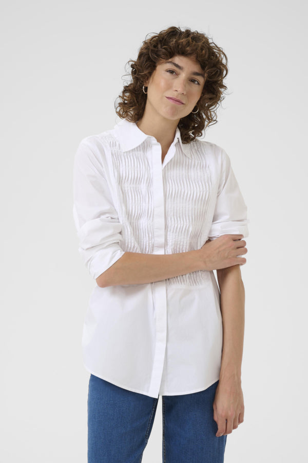 Model wearing white cotton smocked shirt with rolled sleeves
