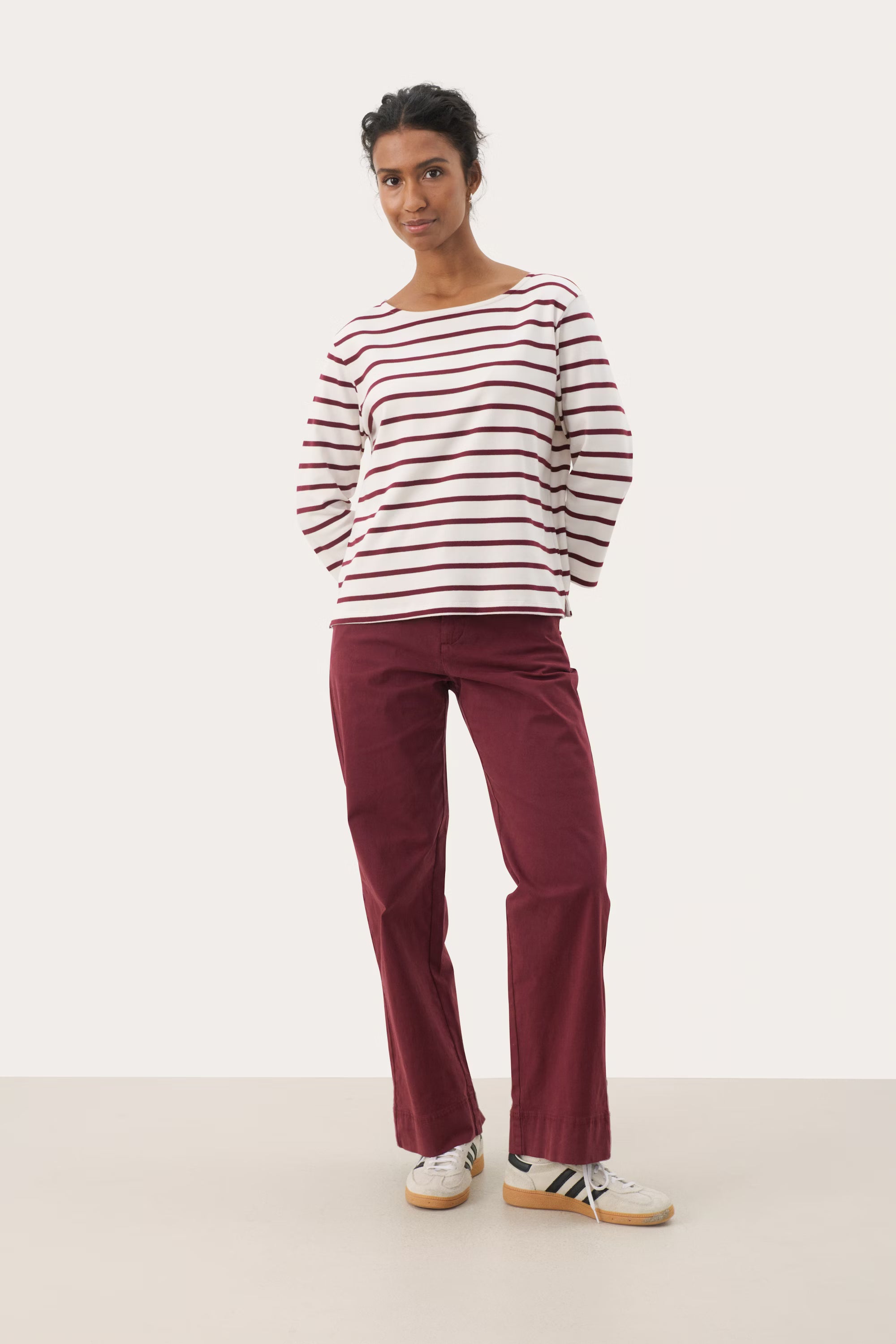Model wearing Part Two NelaPW striped top, showing boat neckline and long sleeves in cream with burgundy stripes.