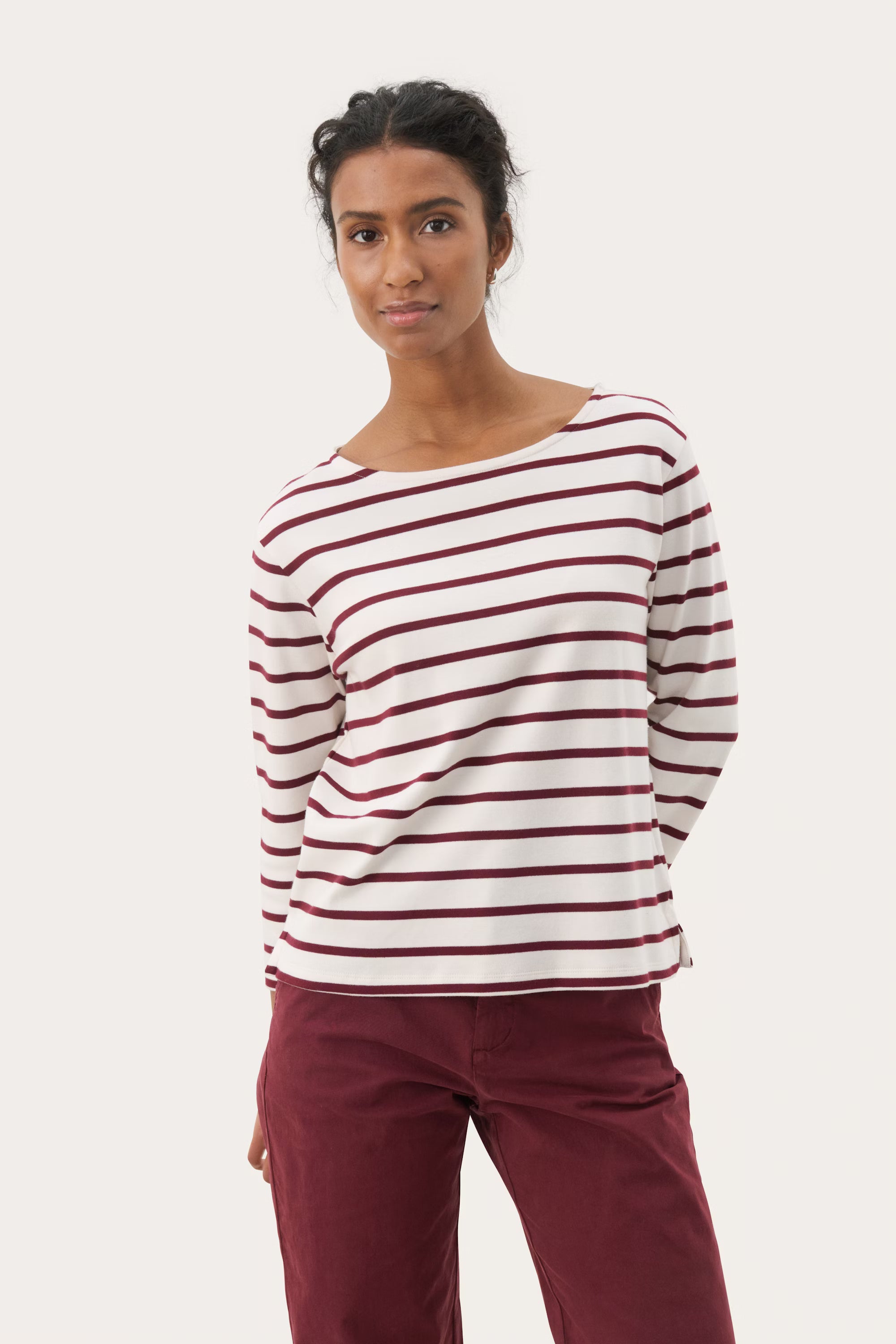 Part Two NelaPW striped top and burgundy trousers, paired with white trainers.