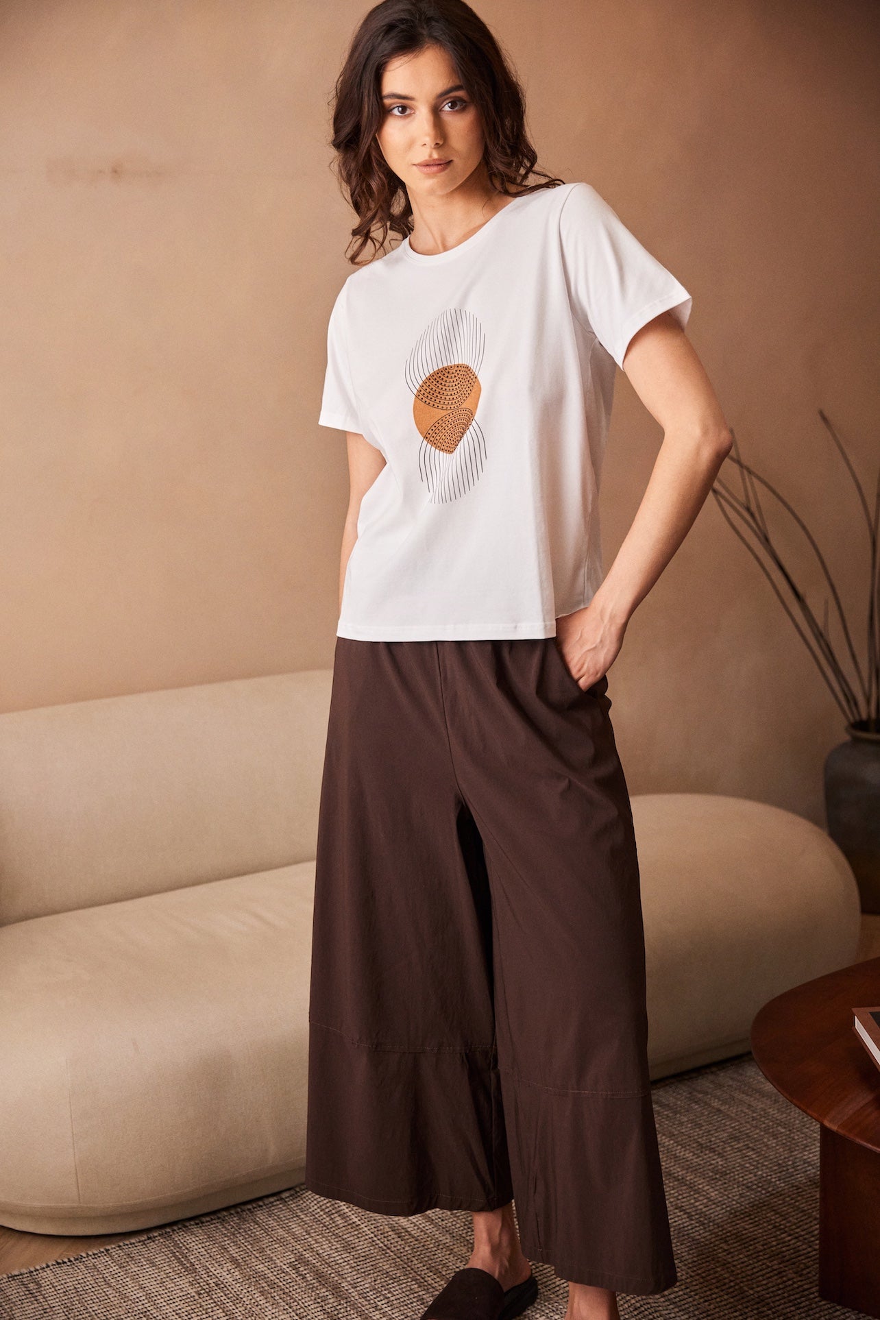 Peruzzi Circle Line Graphic Print Top modelled with brown trousers in lifestyle setting