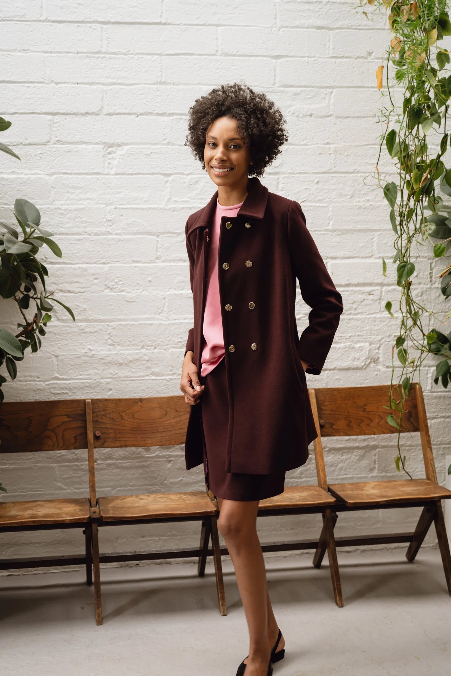 Side view of model in Sisters Havana mini skirt and coat set, styled with heels for occasionwear