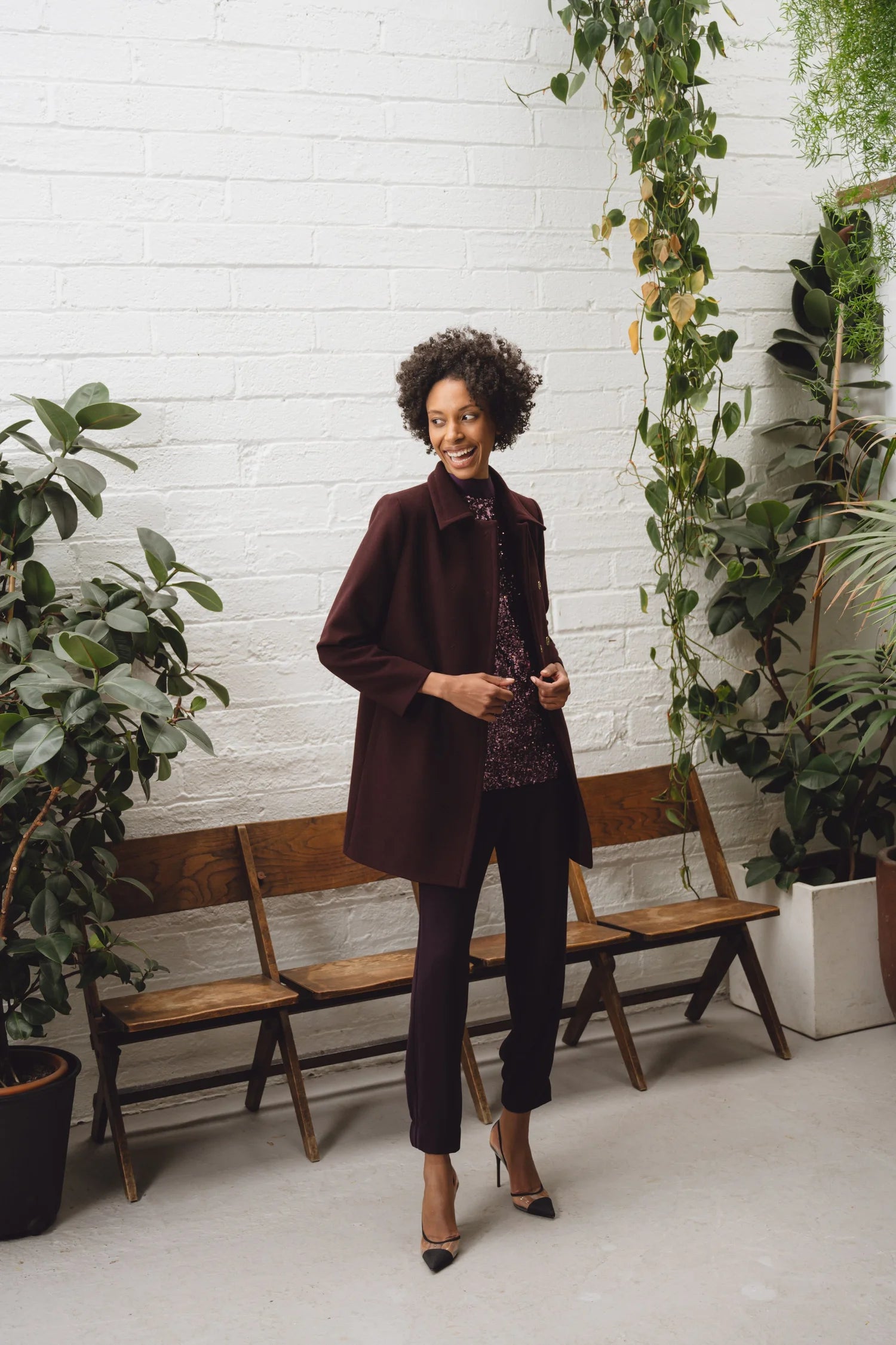 Full-length shot of model in wine mini skirt, matching coat, and bright pink blouse – modern autumn styling