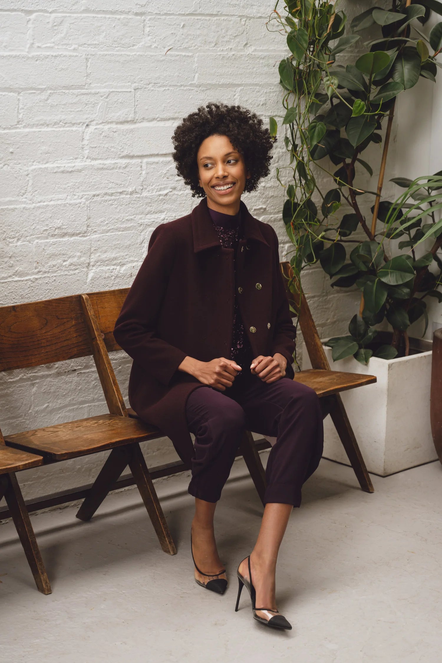 Woman sitting down wearing statement Burgandy suit from Sisters by Caroline Kilkenny