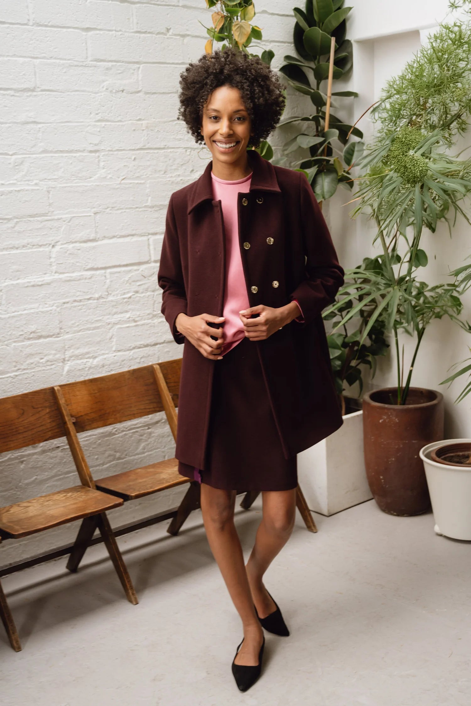 Model wearing wine mini skirt with ruffle stripe and pink satin blouse