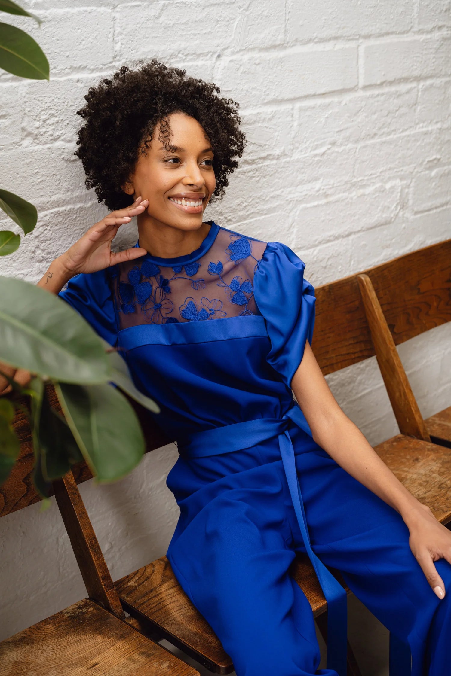 Samantha jumpsuit close-up seated portrait highlighting lace yoke and drape