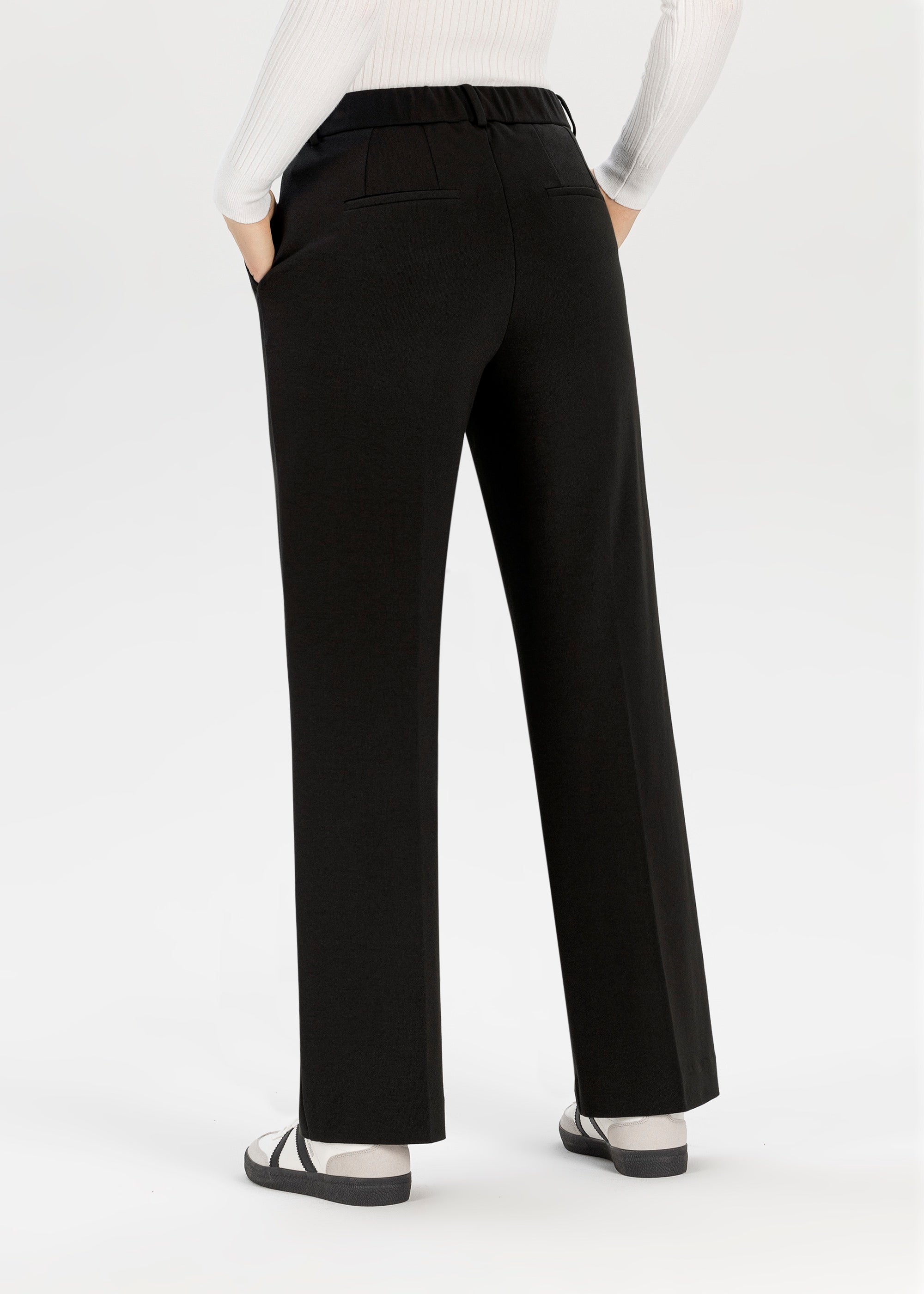 Model wearing Stehmann Fenja2 black jersey wide leg trousers full length from back