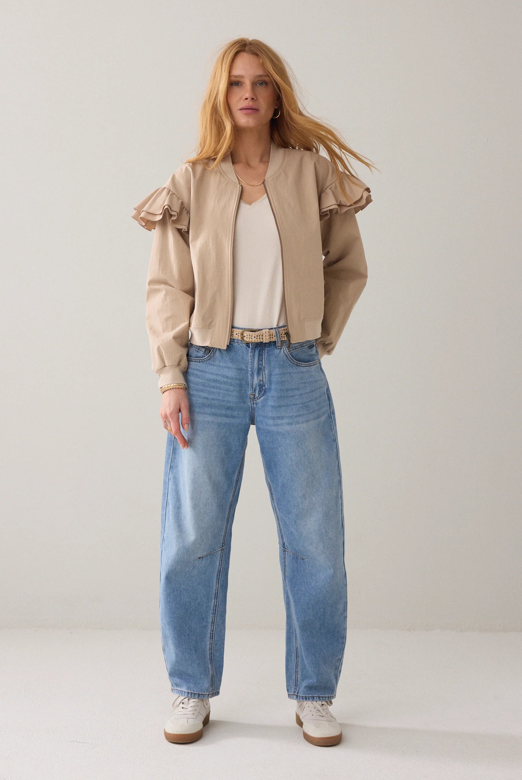 Summum bomber jacket with frill shoulder styled with blue jeans, front view