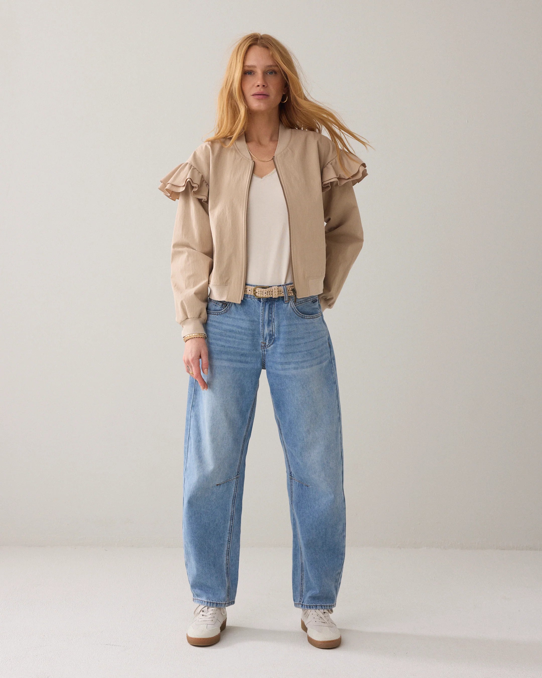 Summum bomber jacket with frill shoulder styled with blue jeans, front view