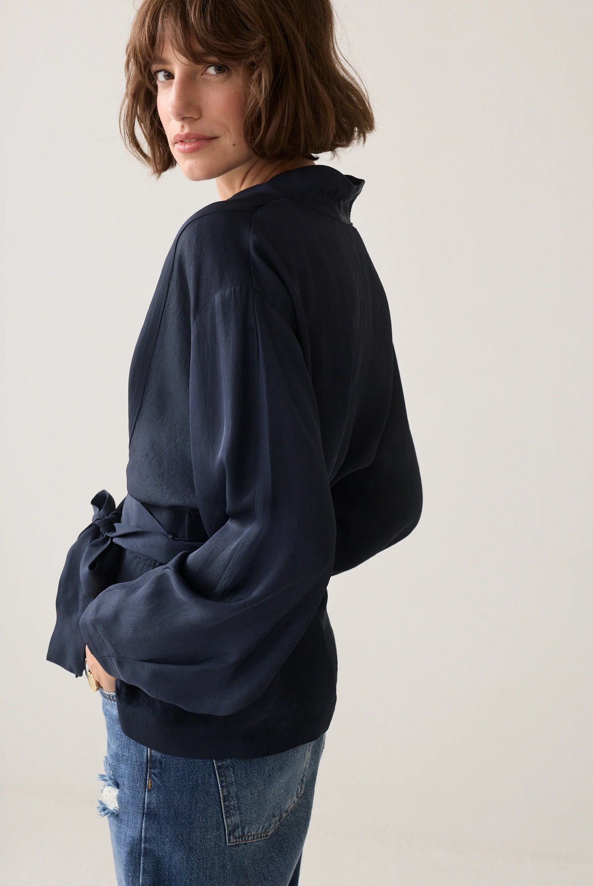 Summum navy V-neck top – side model view showing wide balloon sleeve