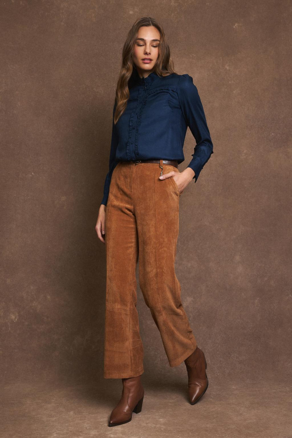 Full-length outfit showing Tinta navy frill blouse and flared cord trousers