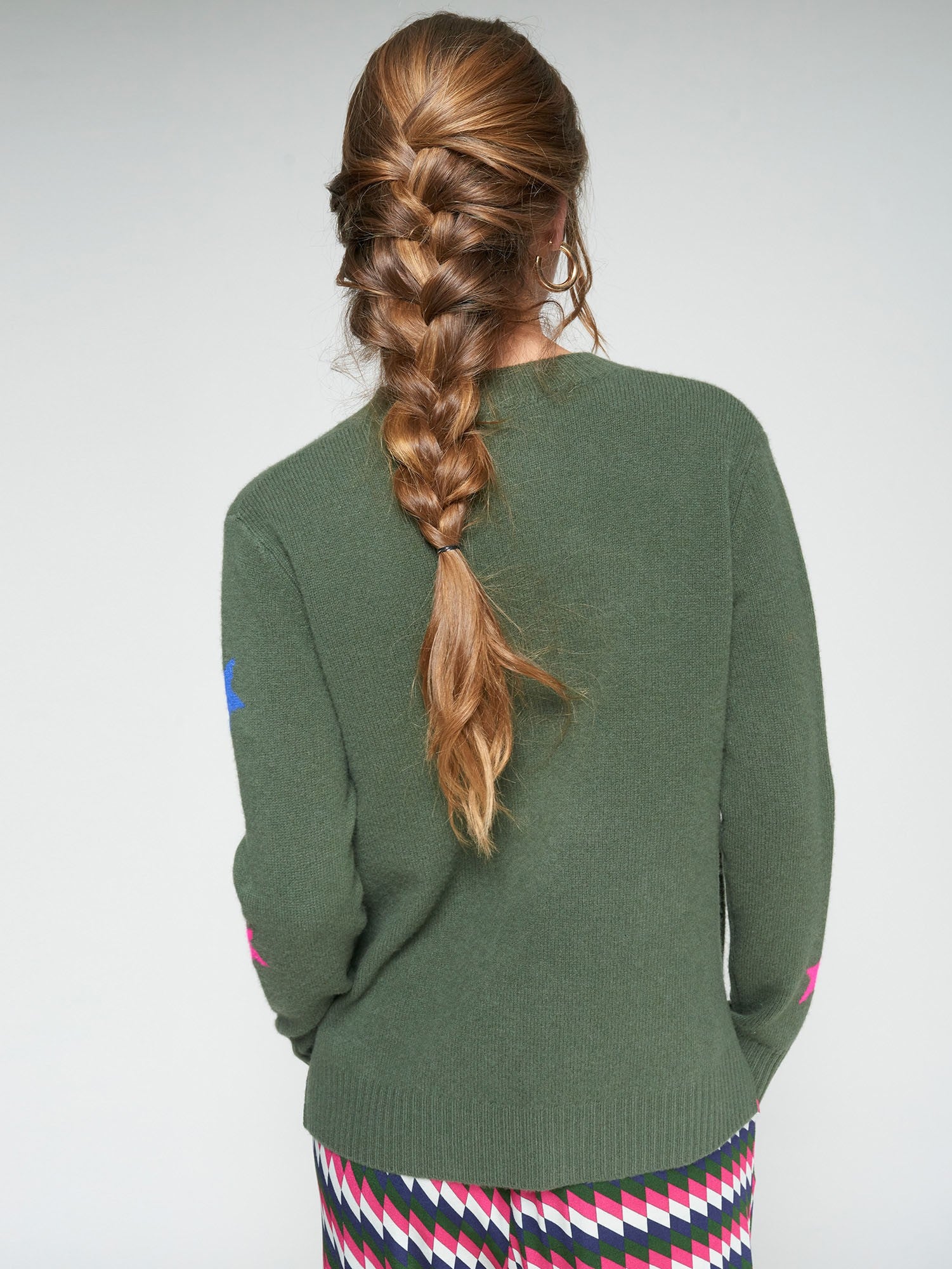 Back view of Vilagallo green cardigan worn with graphic print trousers