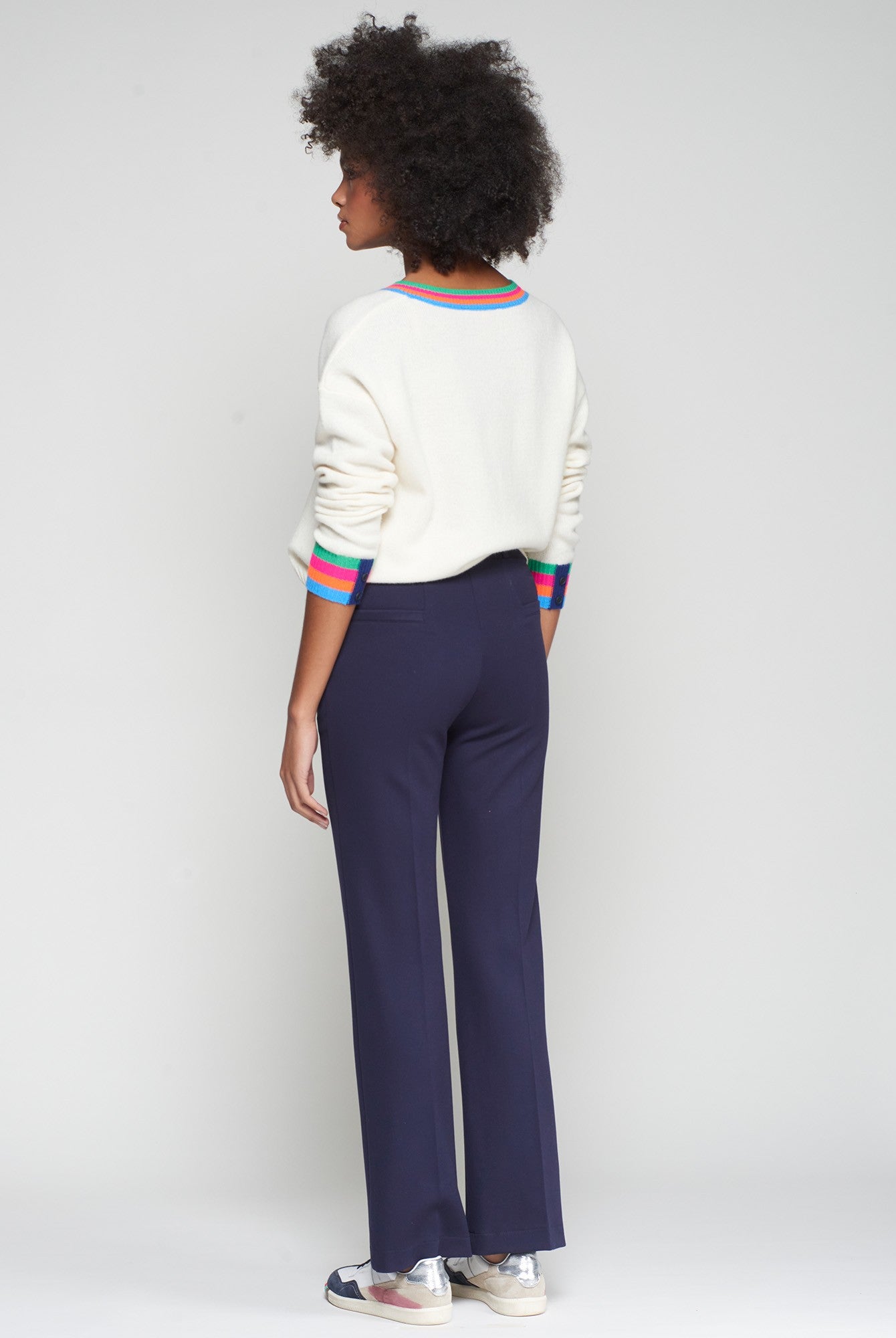Side/back view showing full-length hem and rear welt pockets on navy trousers.
