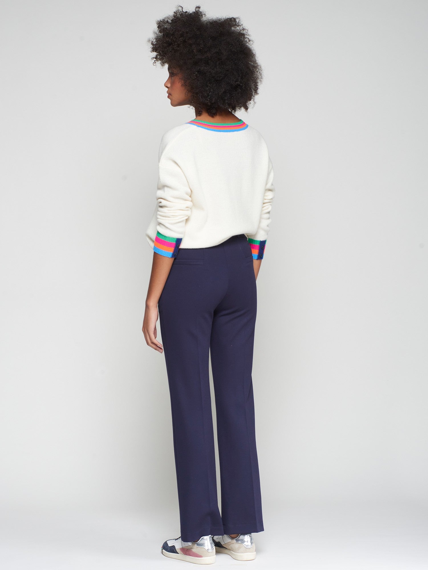 Side/back view showing full-length hem and rear welt pockets on navy trousers.