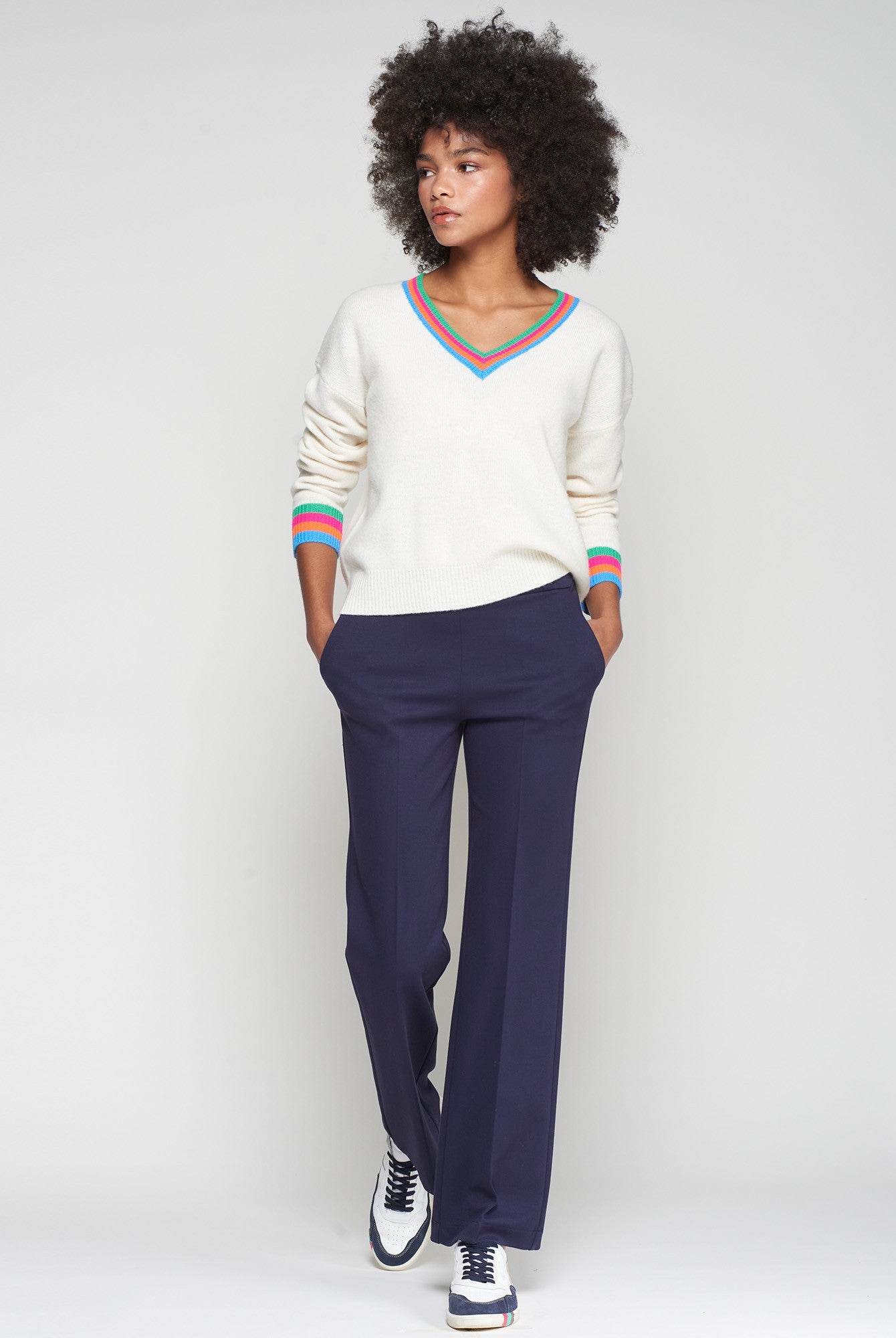 Model in straight-leg navy trousers with clean waistband and front crease, hands in pockets.