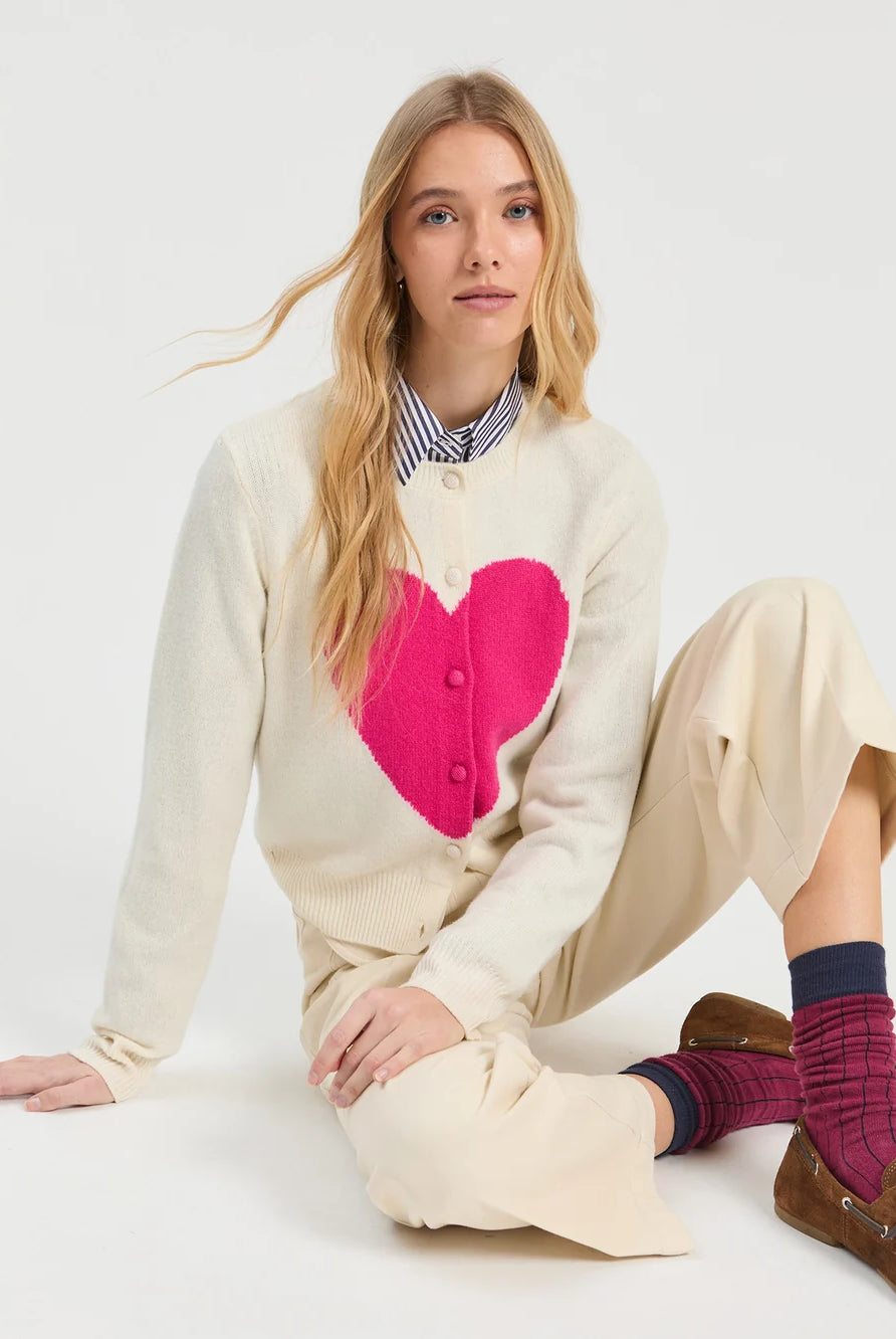 Vilagallo ecru heart intarsia cardigan with fuchsia heart – seated model view