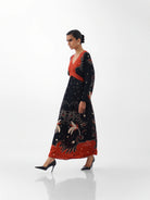 NOIB Aura Old Rose printed maxi dress with long sleeves and contrasting orange-red bodice – side model view.