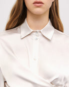 Close-up of cream satin shirt collar with subtle gradient detail
