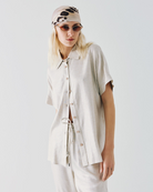 Front view of metallic-effect shirt with short sleeves and side slits