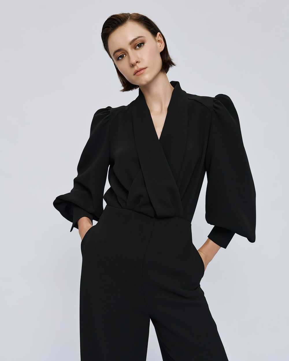 Access Fashion Black Puff Sleeve Jumpsuit three quarter front view showing wrap bodice and pockets.