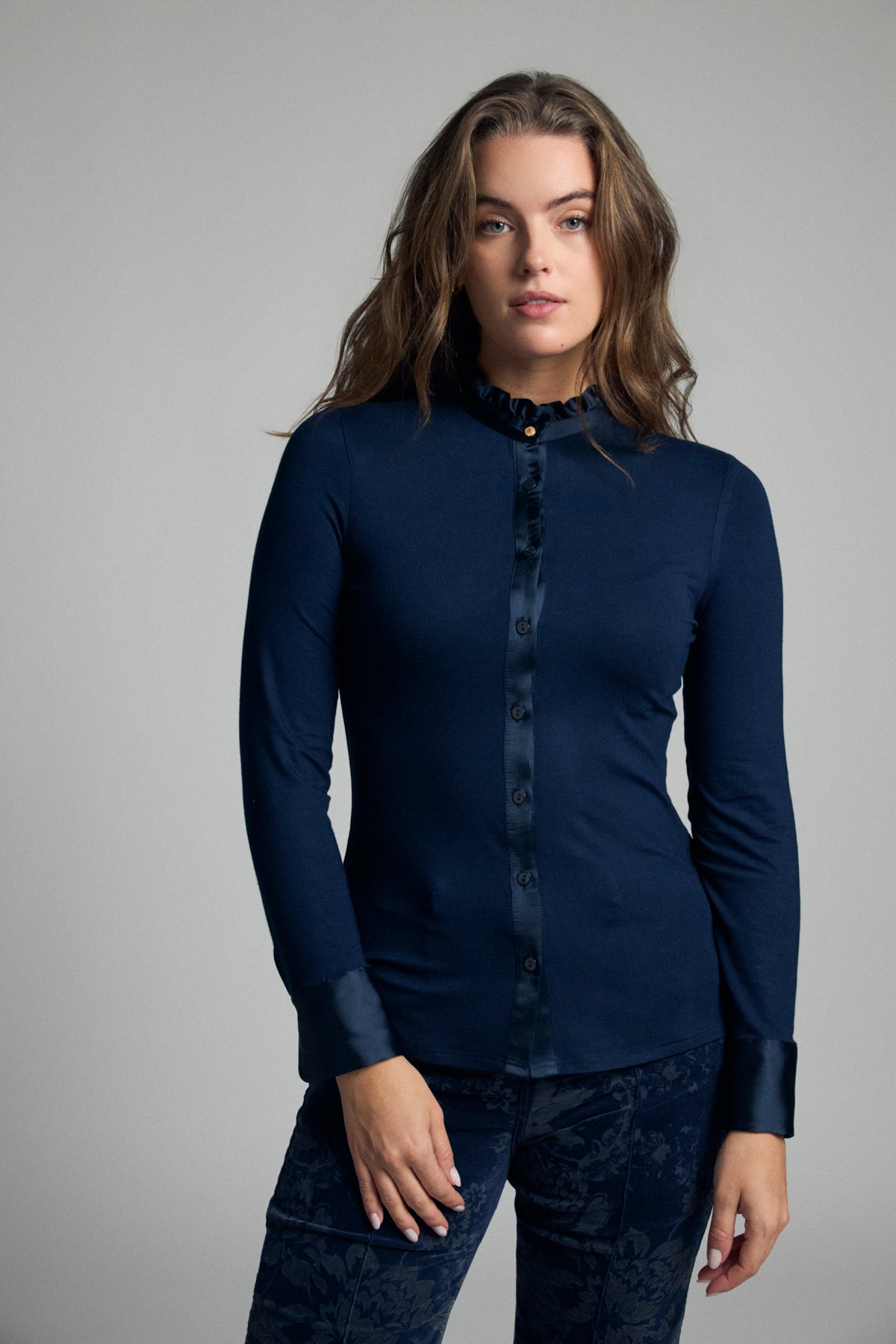 Bariloche Andria navy stretch jersey shirt – front model view showing satin trim and frill collar