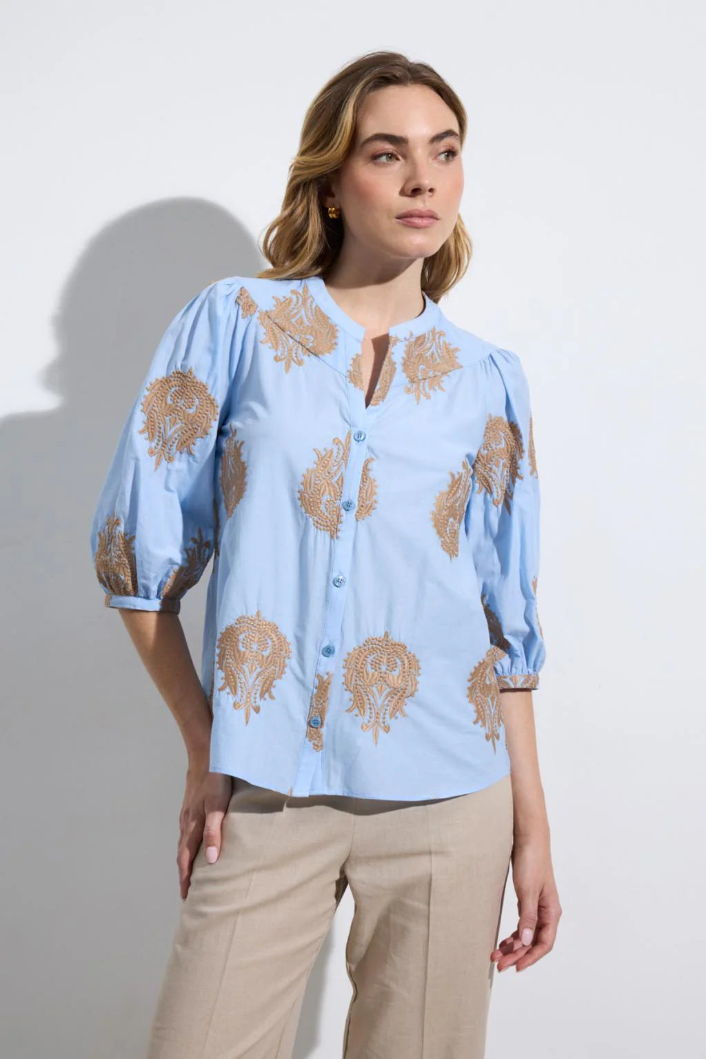 Bariloche Bielsa blue embroidered blouse styled outfit with beige trousers 