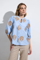 Bariloche Bielsa blue embroidered blouse styled outfit with beige trousers 