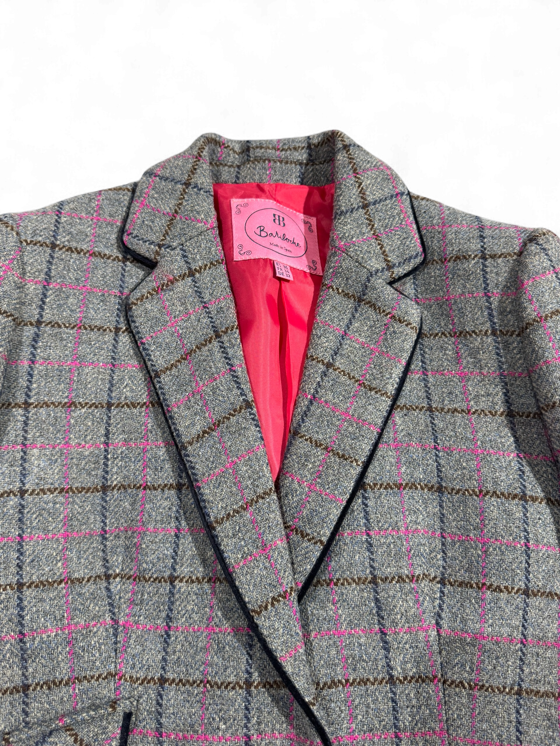 Notch lapel and front pocket detail on grey and pink check Bariloche blazer