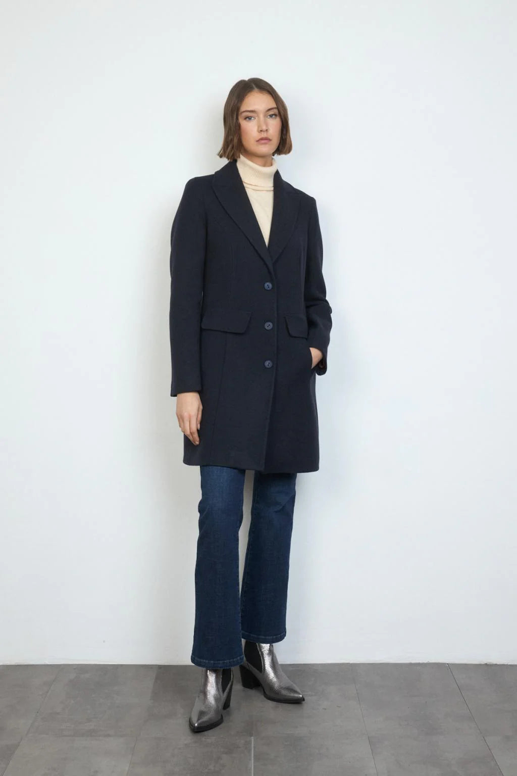 Model wearing Bariloche Cobijo navy wool winter coat with jeans and turtleneck