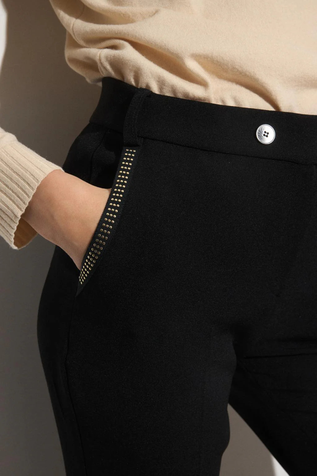 Close-up of Bariloche Luncaria trousers pocket with metallic stud details.