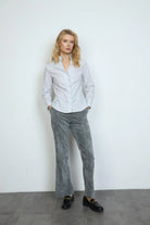 Model wearing Bariloche Onuba white printer shirt with grey trousers, front view