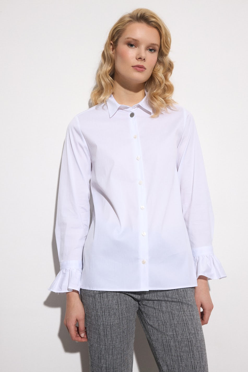 Model wearing Bariloche Ponte tailored white shirt with ruffle sleeves