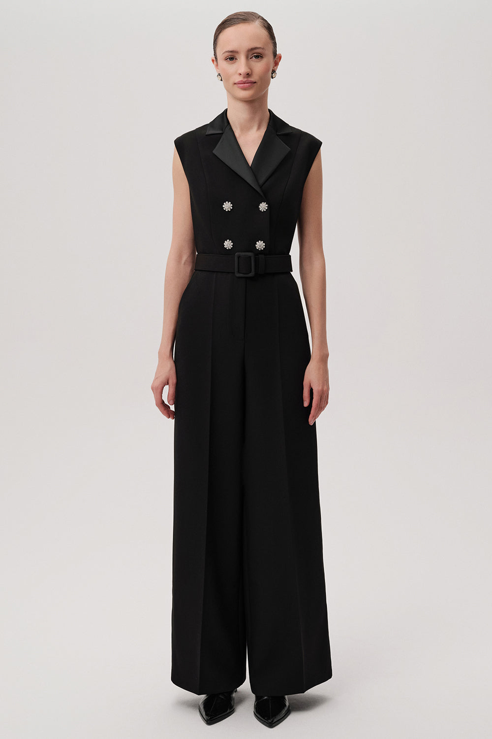 Sleeveless black jumpsuit with satin lapels and crystal buttons by Exquise